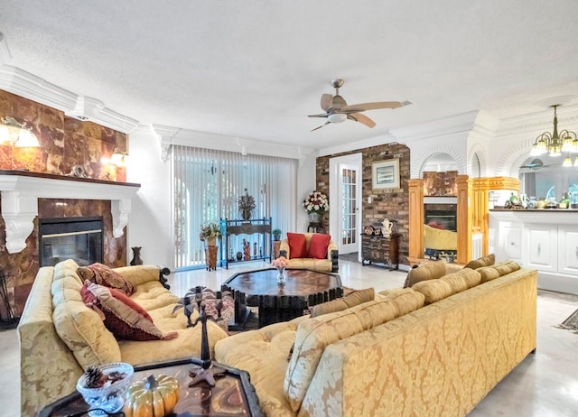 living room featuring ceiling fan with notable chandelier, a textured ceiling, and crown molding