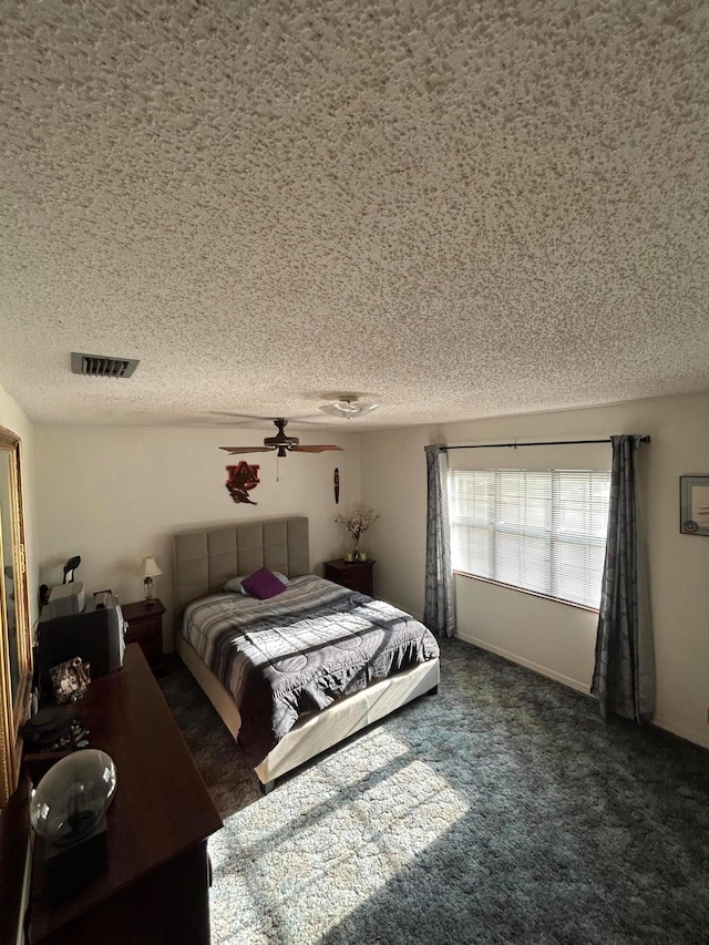 carpeted bedroom with ceiling fan and a textured ceiling