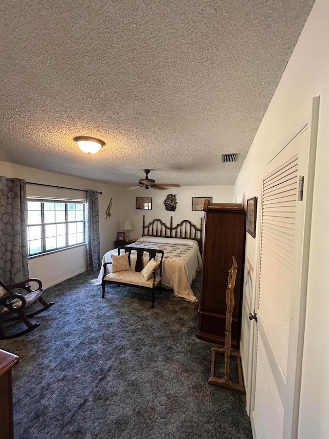 carpeted bedroom with a textured ceiling and ceiling fan