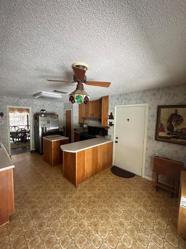 kitchen featuring light tile flooring, ceiling fan, kitchen peninsula, and a textured ceiling