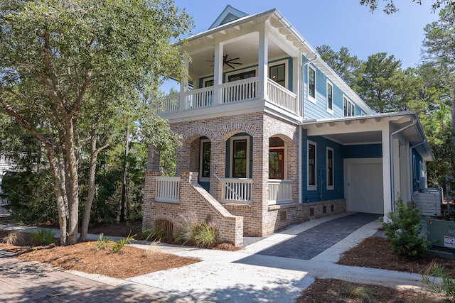 view of front of home featuring covered porch, ceiling fan, a garage, and a balcony