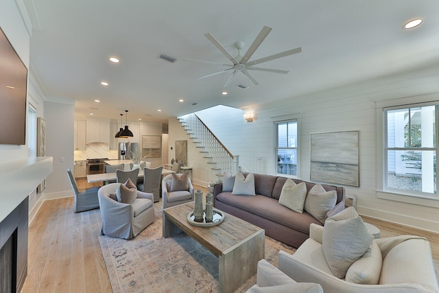 living room featuring a healthy amount of sunlight, ceiling fan, and light hardwood / wood-style floors