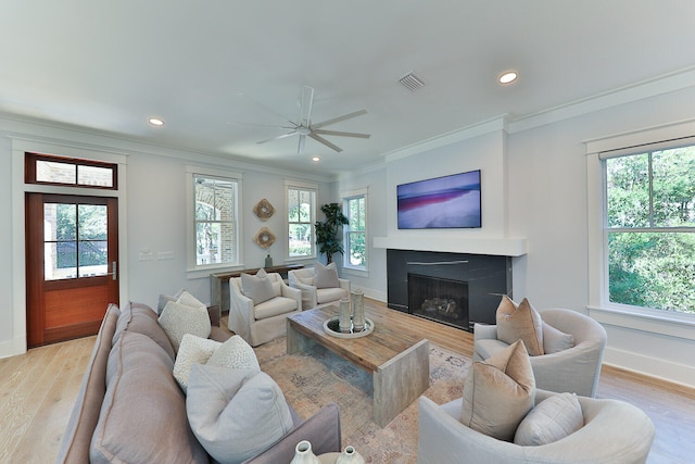 living room featuring light hardwood / wood-style flooring, ceiling fan, and a wealth of natural light