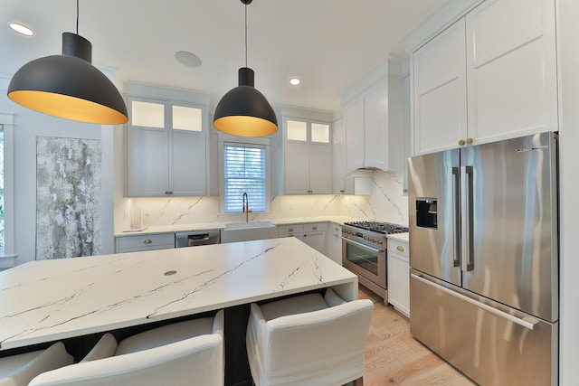 kitchen featuring a kitchen bar, sink, backsplash, and high end appliances