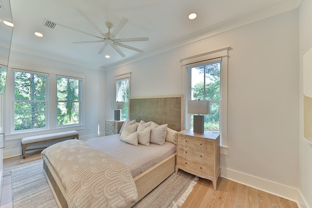 bedroom with ornamental molding, light hardwood / wood-style floors, and ceiling fan