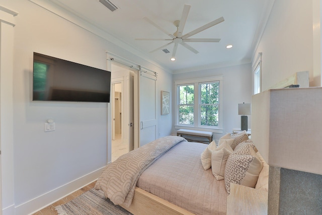 bedroom with ornamental molding, a barn door, light hardwood / wood-style flooring, and ceiling fan