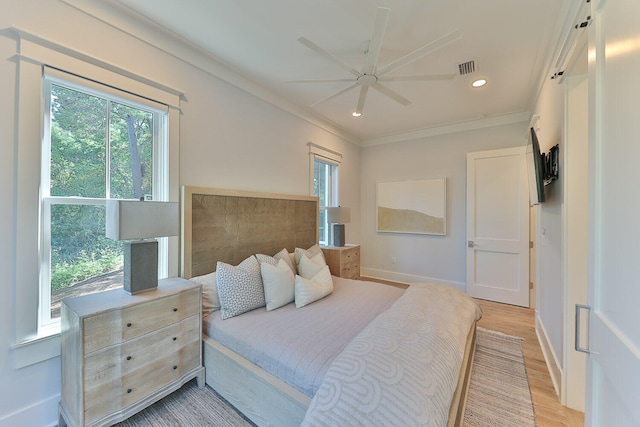 bedroom featuring crown molding, light hardwood / wood-style flooring, and ceiling fan