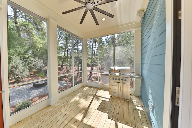 unfurnished sunroom with ceiling fan