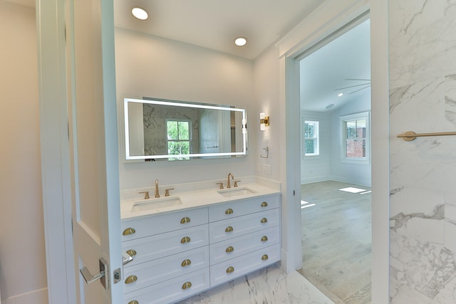 bathroom featuring a wealth of natural light, double vanity, ceiling fan, and lofted ceiling