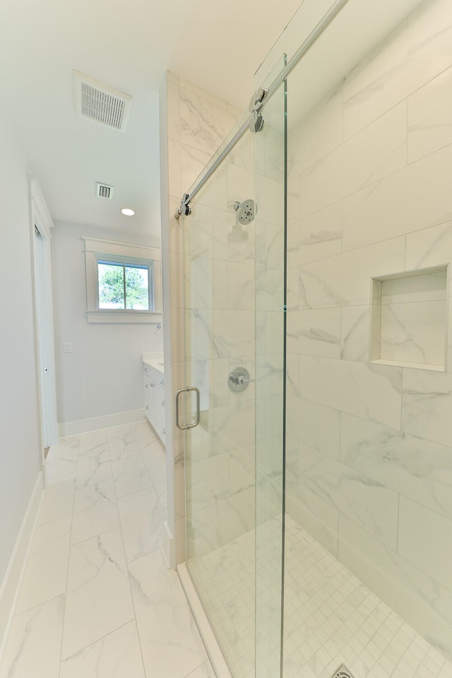 bathroom with a shower with door, vanity, and tile flooring