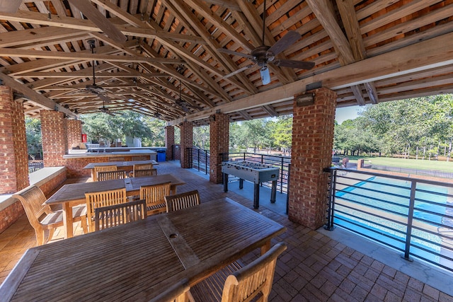 view of patio with a gazebo, an outdoor kitchen, ceiling fan, and a community pool