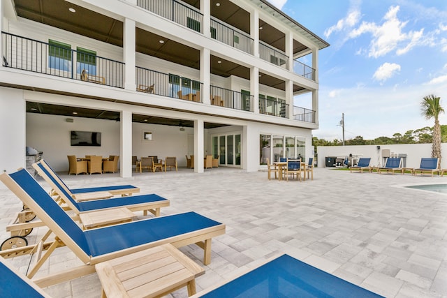 exterior space with a fenced in pool, ceiling fan, and a balcony