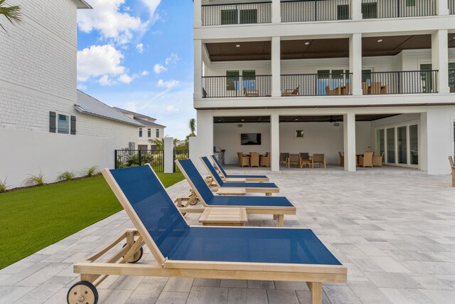 rear view of house with a patio, a balcony, and a lawn