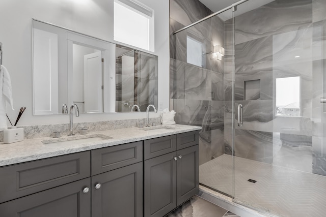 bathroom with tile flooring, oversized vanity, an enclosed shower, and dual sinks