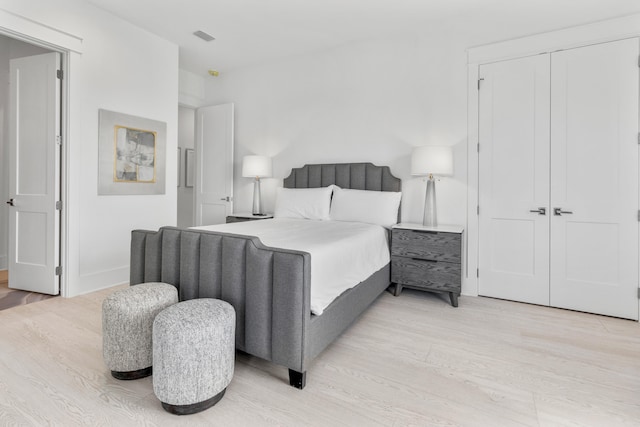 bedroom with light hardwood / wood-style flooring and a closet