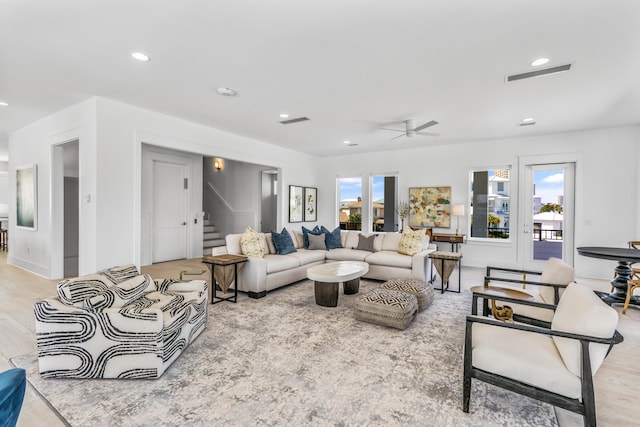 living room featuring light hardwood / wood-style flooring and ceiling fan