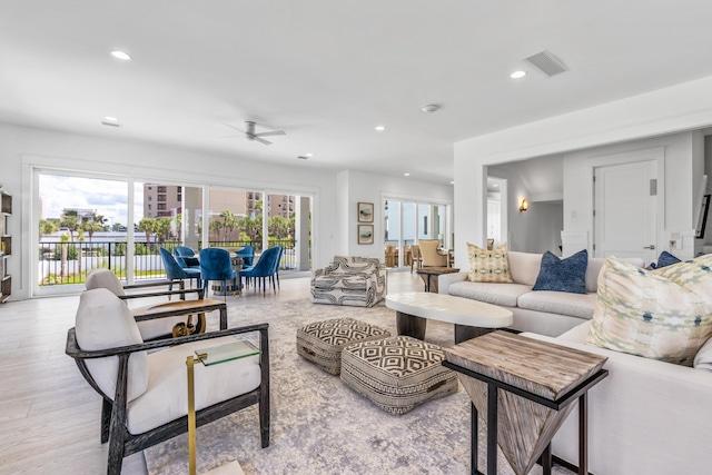 living room with a healthy amount of sunlight, light hardwood / wood-style floors, and ceiling fan