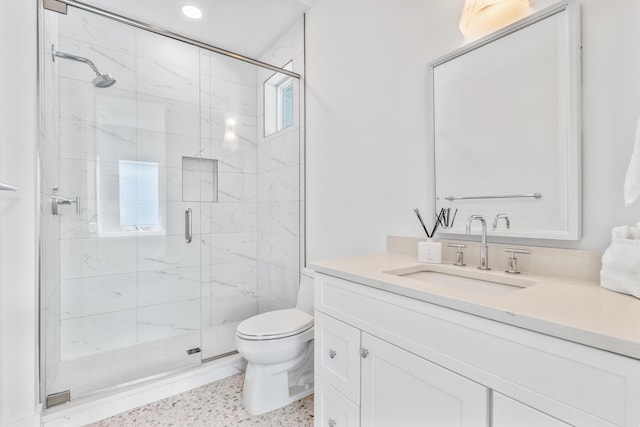 bathroom with a shower with door, oversized vanity, toilet, and plenty of natural light