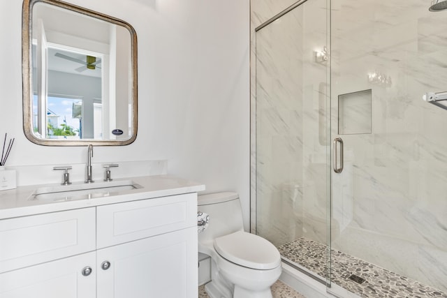 bathroom featuring vanity, a shower with shower door, toilet, and ceiling fan