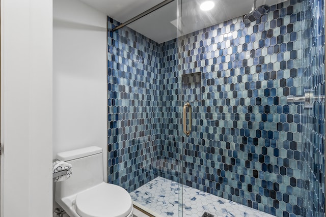 bathroom featuring a tile shower and toilet