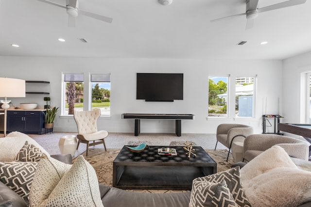 living room with plenty of natural light, light carpet, and ceiling fan