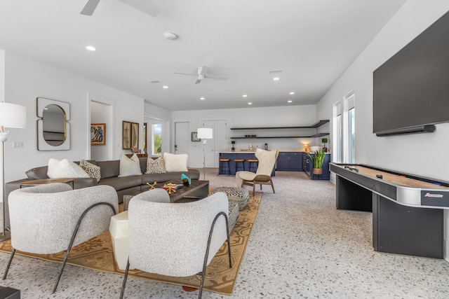 living room featuring ceiling fan and a wealth of natural light