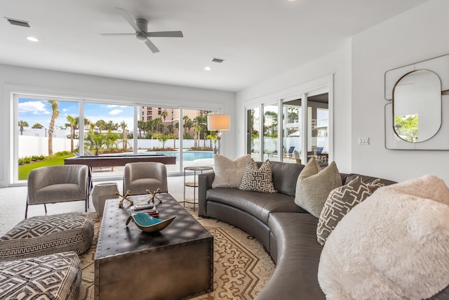 carpeted living room featuring a wealth of natural light and ceiling fan