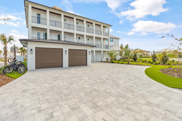 view of front of property featuring a balcony and a garage