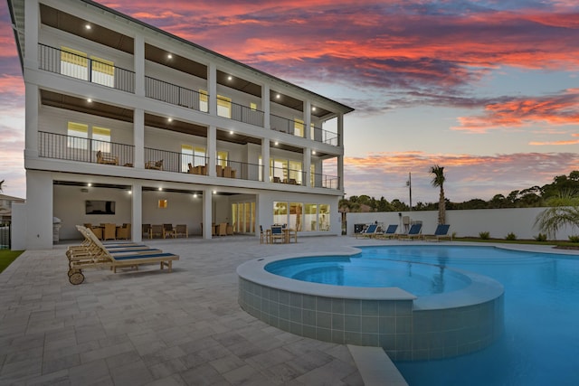 pool at dusk with a patio