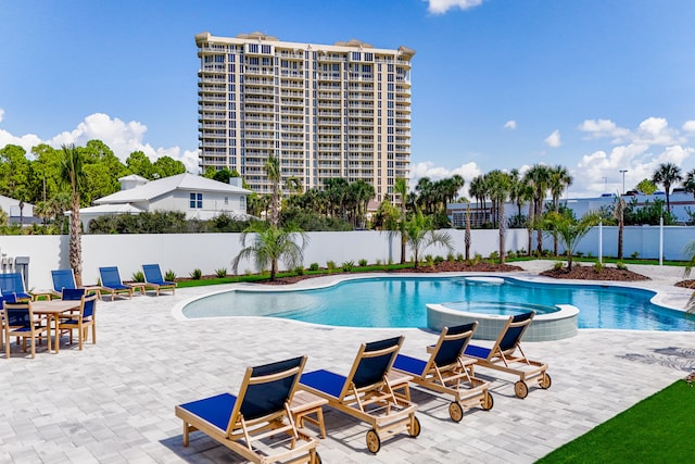 view of pool with a patio area and an in ground hot tub