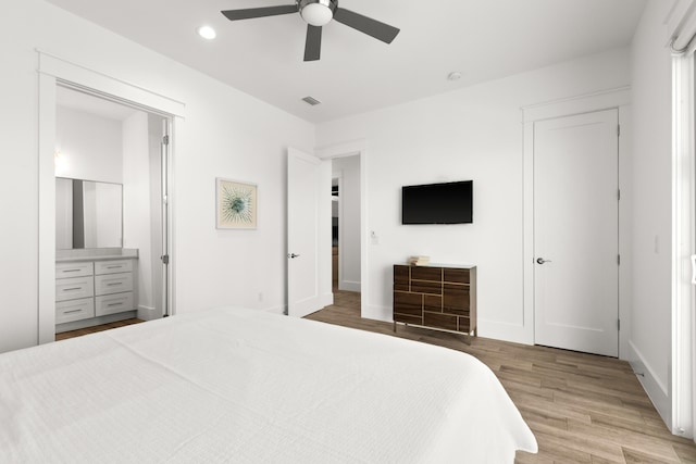 bedroom featuring light hardwood / wood-style floors, ceiling fan, and ensuite bathroom