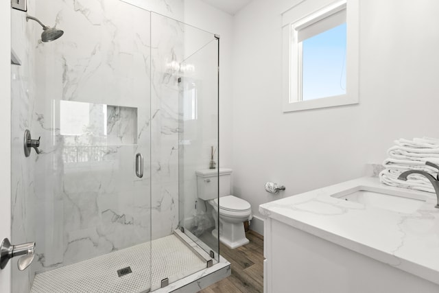 bathroom featuring walk in shower, wood-type flooring, vanity, and toilet