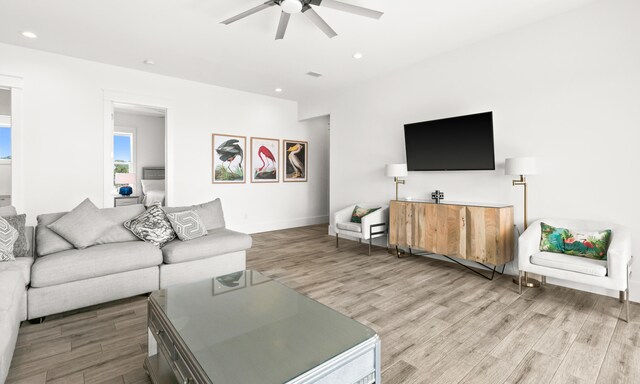 living room featuring light hardwood / wood-style flooring and ceiling fan