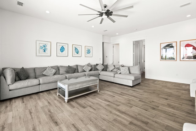 living room with light hardwood / wood-style flooring and ceiling fan