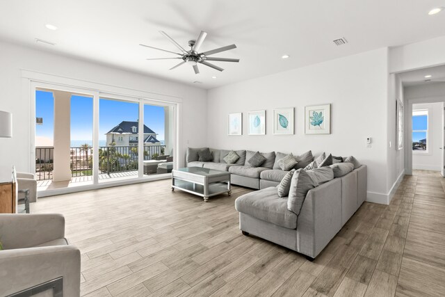 living room featuring a wealth of natural light, ceiling fan, and light hardwood / wood-style floors