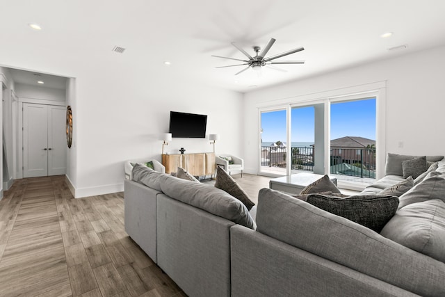 living room featuring ceiling fan and light wood-type flooring