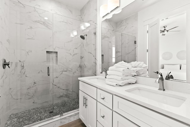 bathroom with an enclosed shower, ceiling fan, and double sink vanity