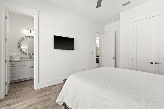 bedroom with a closet, light wood-type flooring, ceiling fan, and connected bathroom