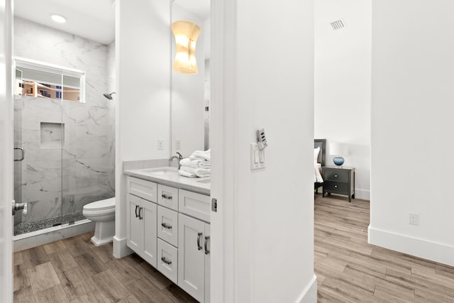 bathroom with vanity, an enclosed shower, toilet, and hardwood / wood-style flooring