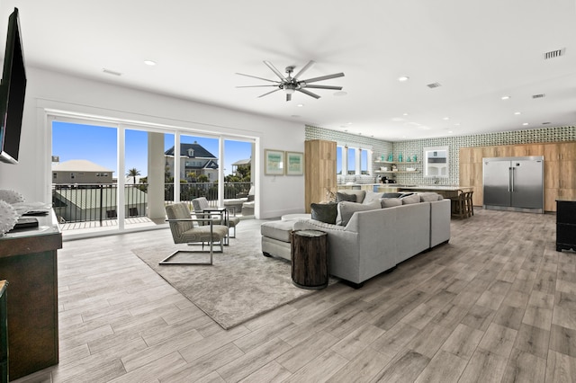 living room featuring ceiling fan and light wood-type flooring