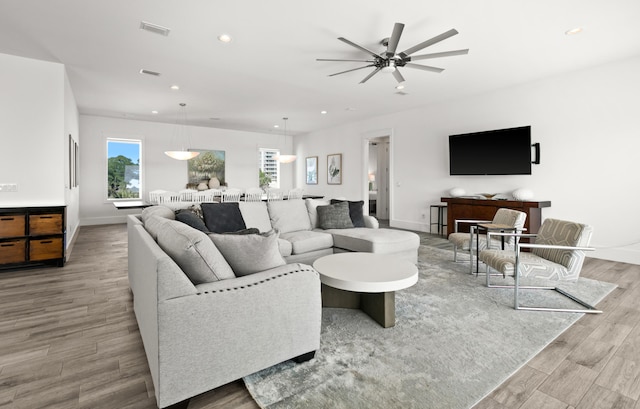 living room featuring light hardwood / wood-style flooring and ceiling fan