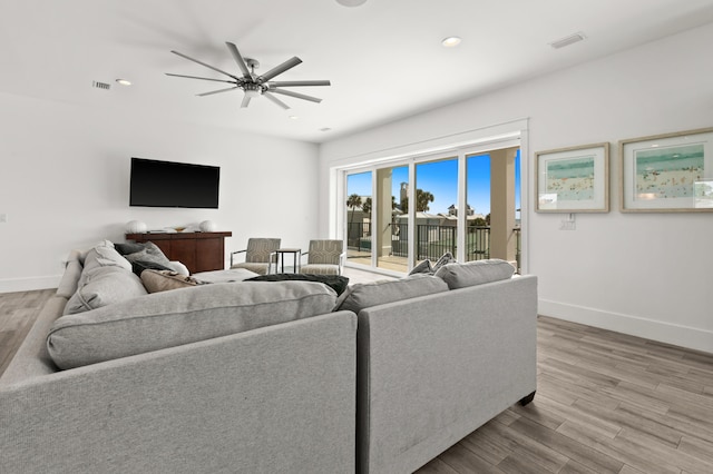 living room with light hardwood / wood-style flooring and ceiling fan