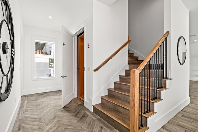 stairway with light parquet floors