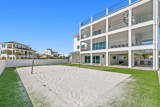 view of home's community featuring volleyball court, a lawn, and a patio area