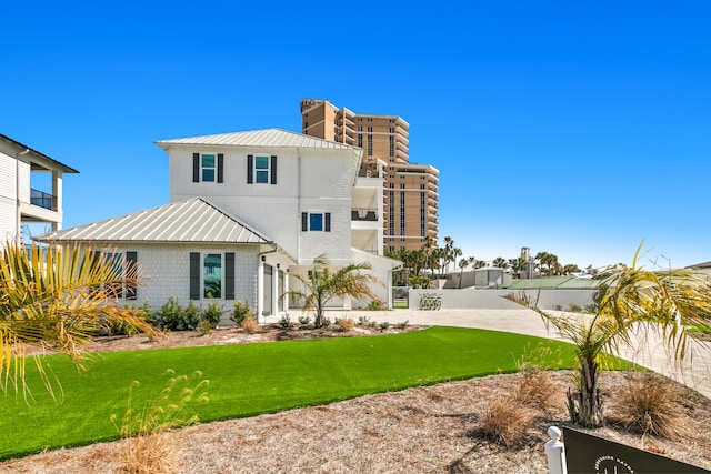 view of front of property with a front lawn and a balcony