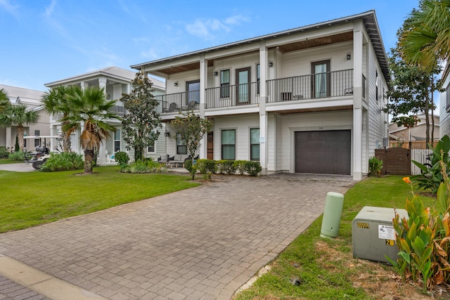 view of front facade with a balcony, a garage, and a front yard