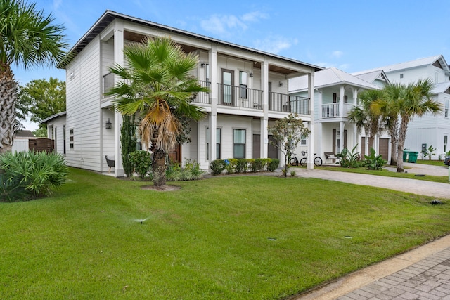 view of front facade with a front lawn and a balcony