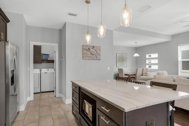 kitchen featuring dark brown cabinetry, a kitchen island, independent washer and dryer, stainless steel fridge with ice dispenser, and pendant lighting