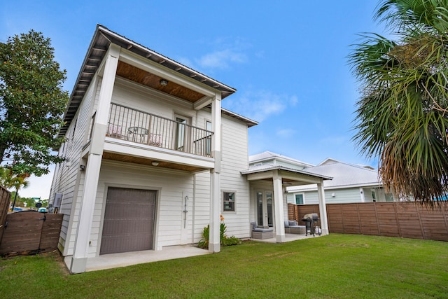 back of house with a patio area, a balcony, and a lawn