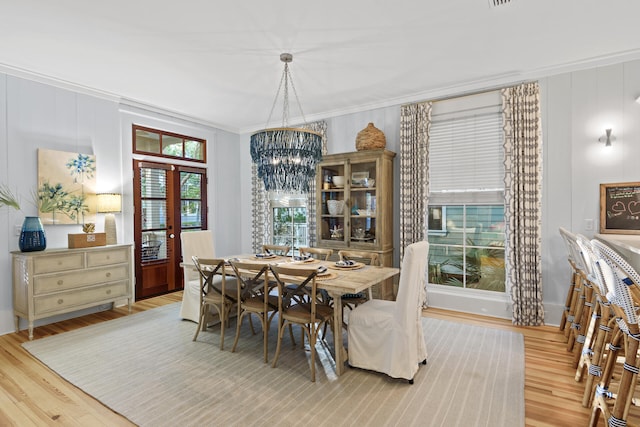 dining room with a notable chandelier, light hardwood / wood-style flooring, and a healthy amount of sunlight